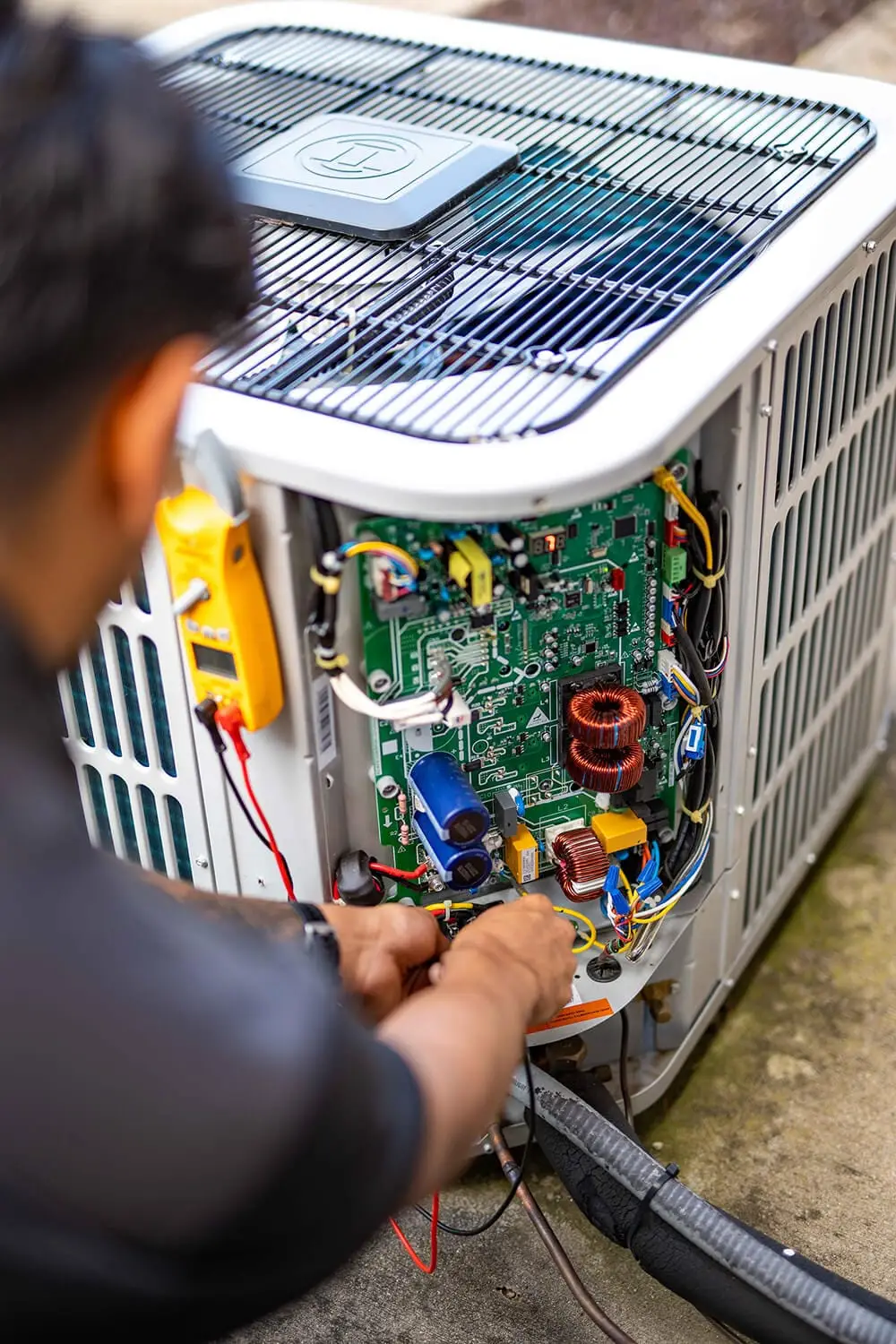 Airstream Services HVAC technician performing electrical diagnostics on the circuit board of a residential AC unit in Middle Tennessee.
