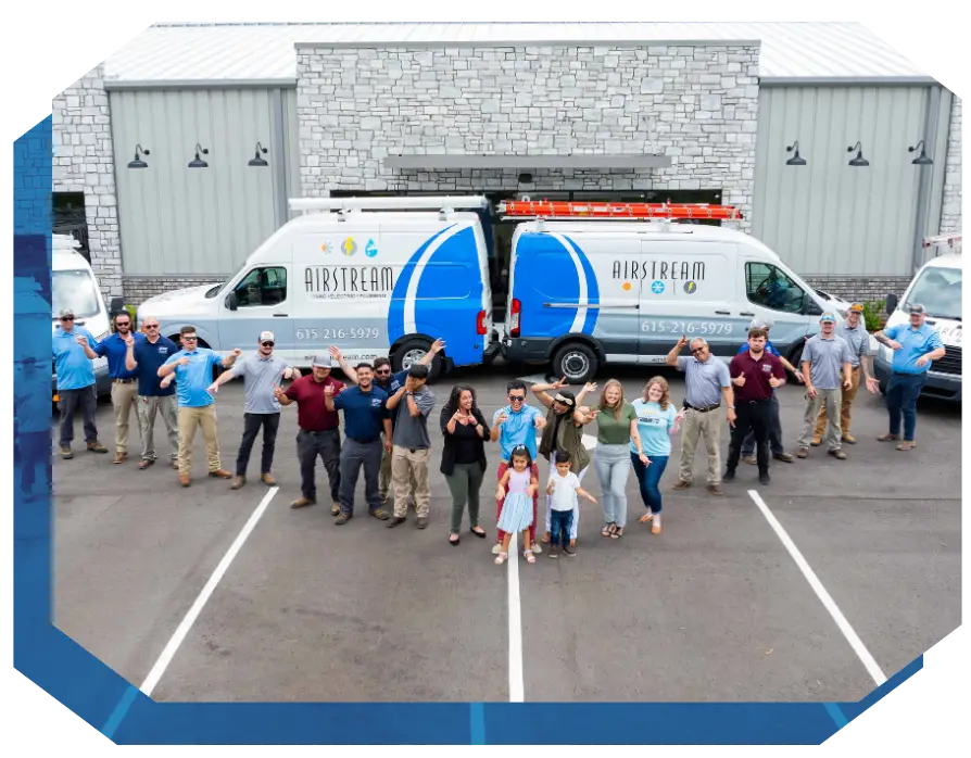 Airstream Plumbing, Heating & Air team and family stand in front of branded service vans.